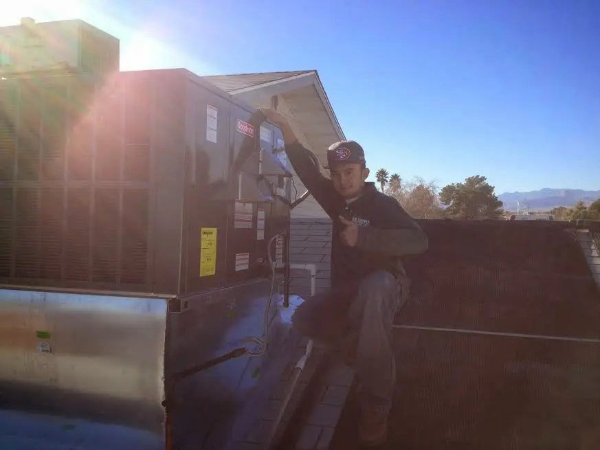 HVAC technician performing Heat Pump Repair on a rooftop unit in Glenwood Springs